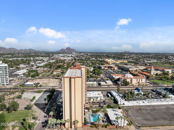 Panoramic view of cityscape with tall buildings and mountains in the background.