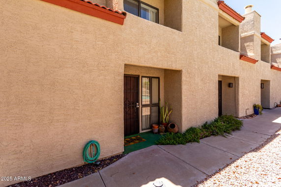 Front view of a multi-story building with textured walls and covered entrances.
