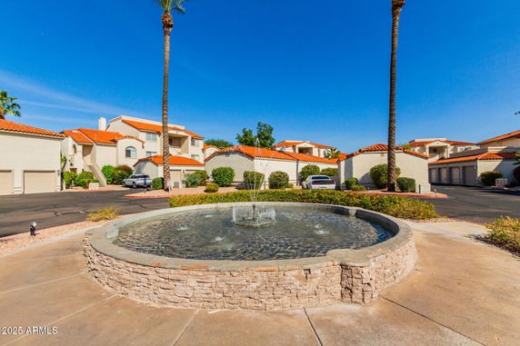Front view of a residential complex with white walls and orange tile roofs.