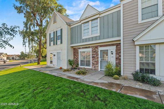 Front view of a two-story townhouse with brick and siding exterior.
