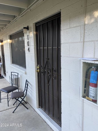 View of a building exterior with a metal security door and window.