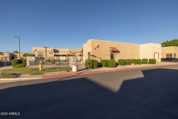 Front view of a single-story building with a gated entrance.