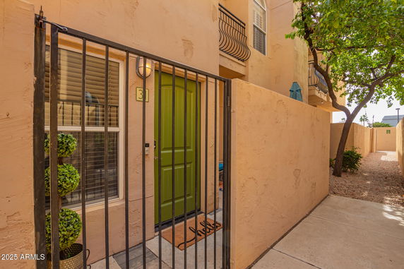Entrance view of a building with a green door and adjacent window.