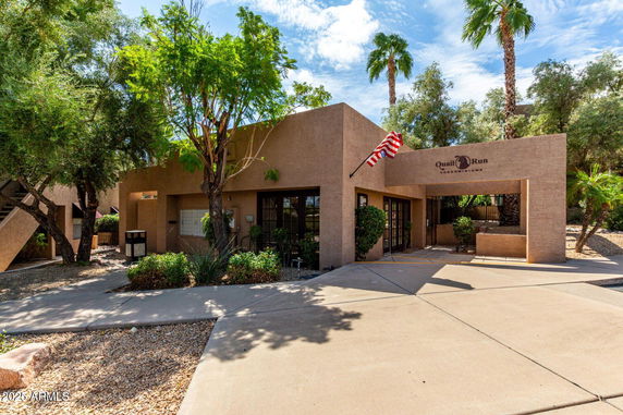 Front view of a condominium building with an entrance and an American flag.