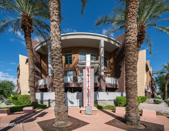 Front view of a multi-story building with palm trees and a sign marked 'Westgate'.