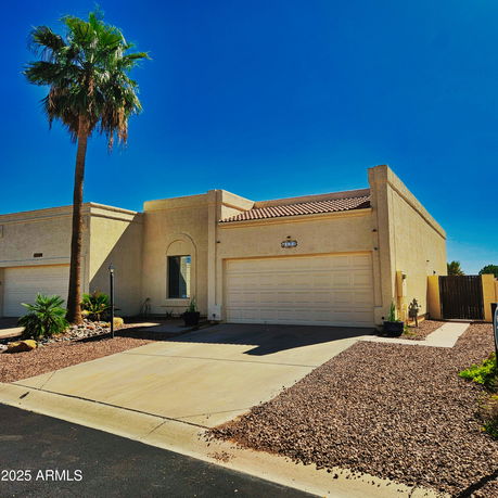 Front view of a house with a double garage and flat roof.