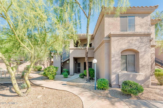Front view of a two-story building with an outdoor staircase.
