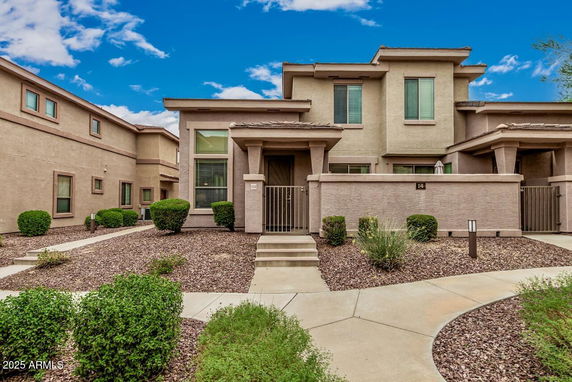 Front view of a modern two-story house with a gated entrance.