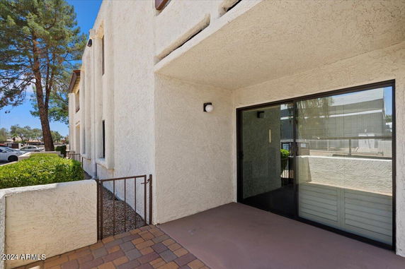 Front view of a building with beige stucco exterior and sliding glass doors.
