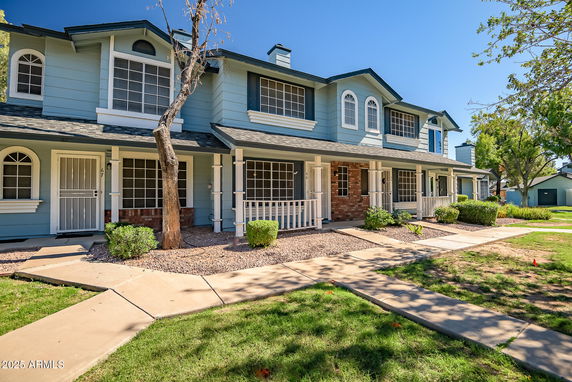 Front view of a two-story townhouse with blue siding and white trim.