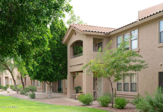 Front view of a two-story building with a balcony and multiple windows.