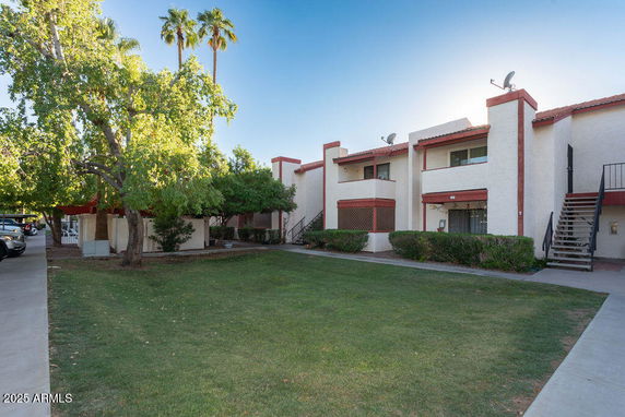 Front view of a two-story building with red roofing and satellite dishes.
