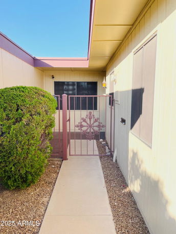 Entrance view of a house with a gated walkway and exterior siding.