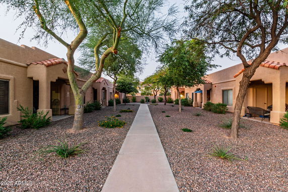 Front view of a series of connected single-story units with a pathway between them.