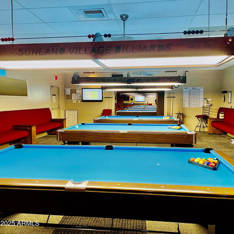 Interior view of a billiards room with multiple pool tables and seating.