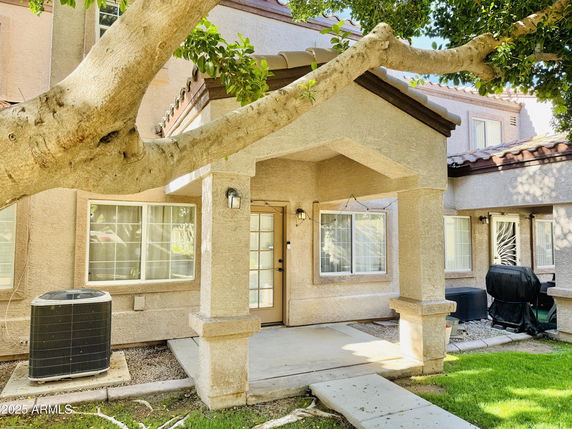Front view of a two-story house with a covered entrance and large windows.