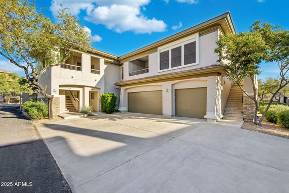 Front view of a two-story building with a double garage and stairs.