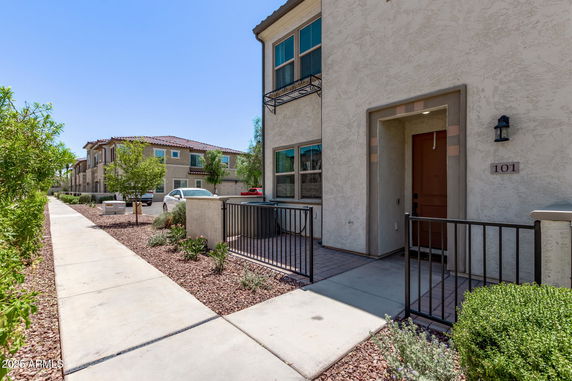 Front view of a two-story residential building with a gated entryway.