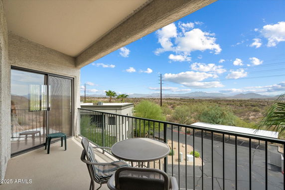 Balcony with a view of expansive landscape and distant mountains.