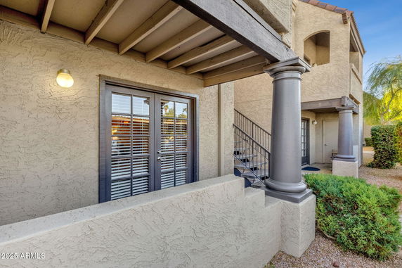 Front view of a two-story house with a staircase and French doors.