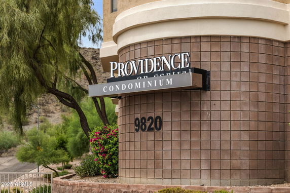 Corner view of a condominium building with visible sign.