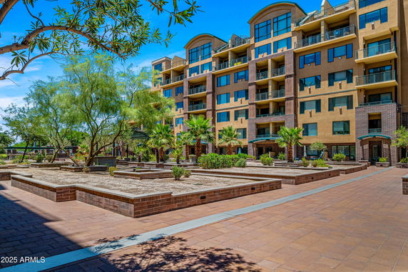Front view of a multi-story residential building with balconies and large windows.