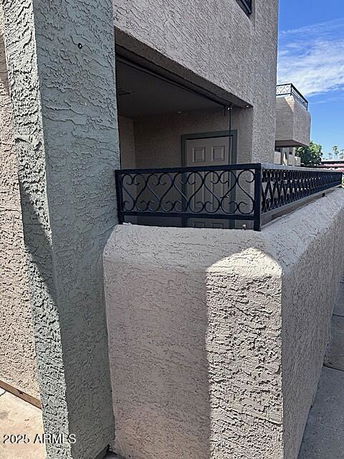 Front view of a multi-story building with a balcony and textured exterior walls.