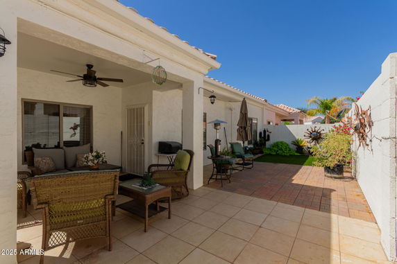 Backyard patio area with outdoor seating and tiled floor.
