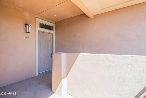 Front view of a building entrance with a numbered door and overhang.