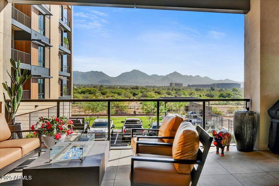 Outdoor patio with seating area and panoramic view of mountains.
