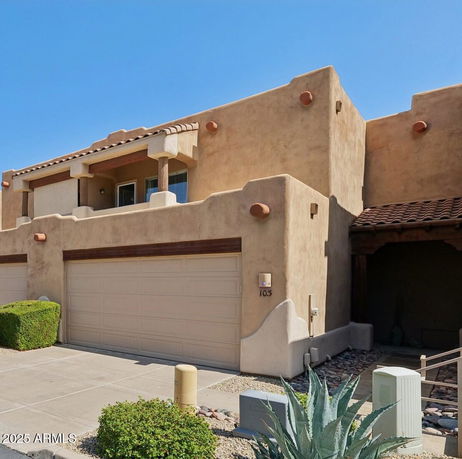 Front view of a two-story house with a double garage and stucco exterior.