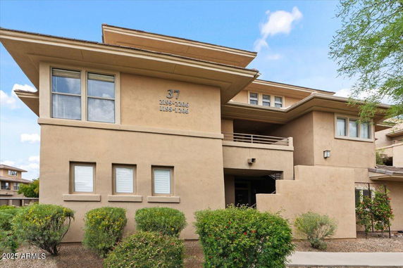 Front view of a multi-story building with beige exterior and multiple windows.