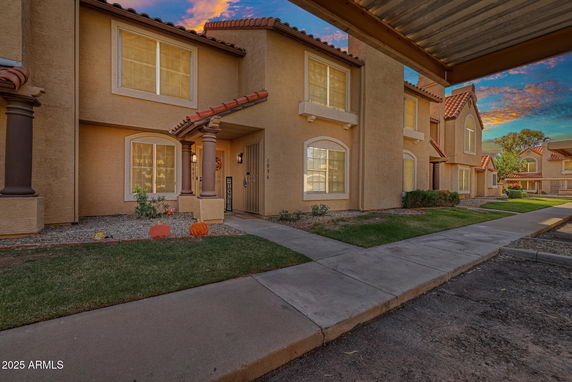 Front view of a two-story townhouse with a sloped roof and a covered entrance.
