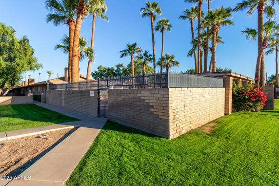 Front view of a house with a brick wall and iron gate.