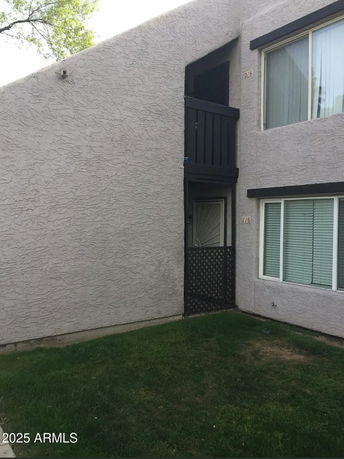Front view of a two-story apartment building with a door and windows.