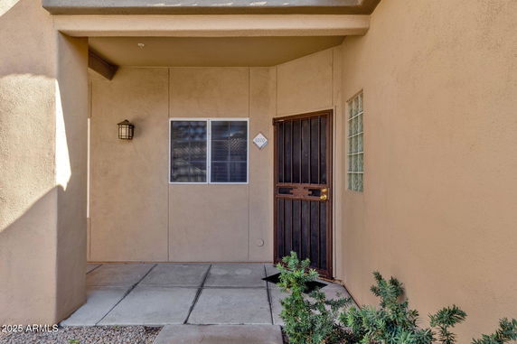 Front view of a house entrance with a wooden door and a small window.
