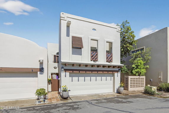 Front view of a modern two-story house with a garage and unique architectural design elements.