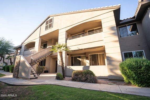 Front view of a two-story building with outdoor stairs and balconies.