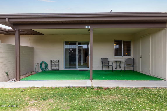 Front view of a house with a covered patio and sliding glass doors.