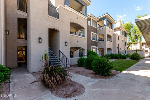 Front view of a multi-story apartment building with balconies.
