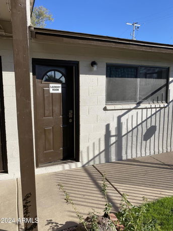 Front view of a building with a door labeled 'Laundry Room' and a window beside it.