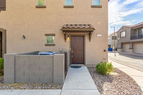 Front view of a house with a small entrance pathway and a brown door.