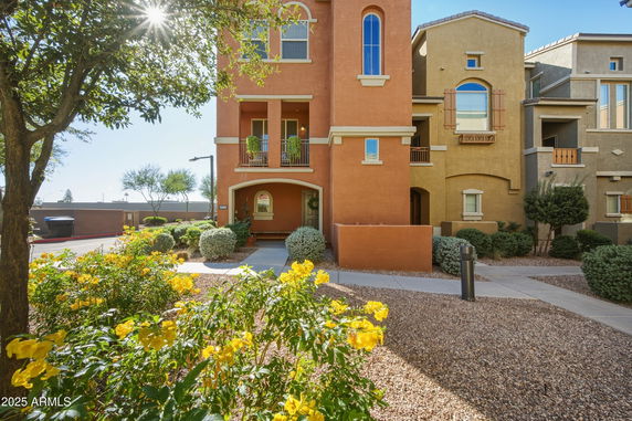 Front view of a multi-story building with a beige and brown facade.