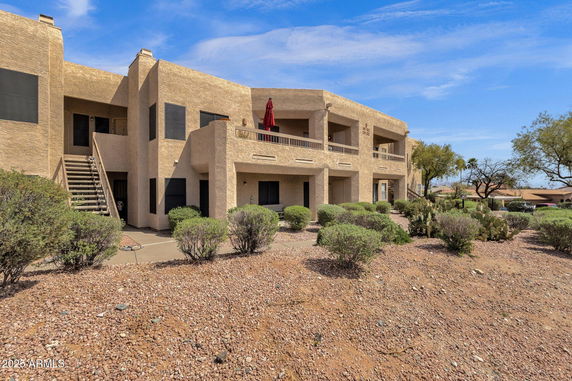 Front view of a two-story building with stucco exterior and balconies.