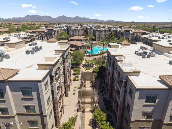 Panoramic view of a residential complex with multiple buildings and a swimming pool in the center.