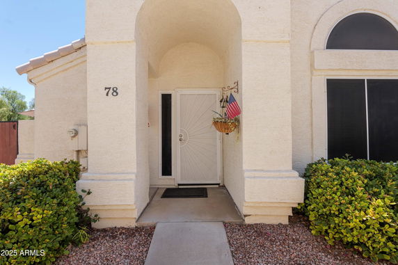 Front entrance of a house with a white door and arched design.