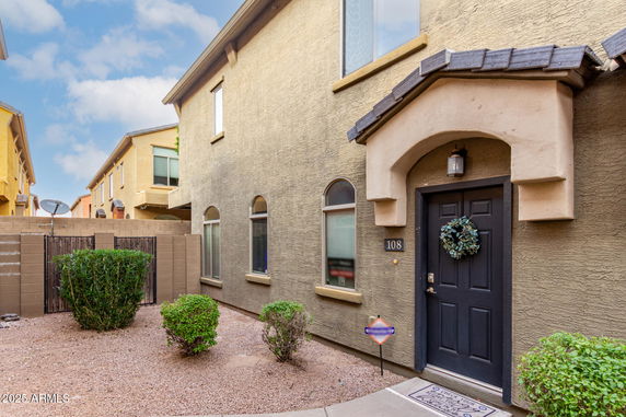 Front view of a two-story house with arched windows and a black door.