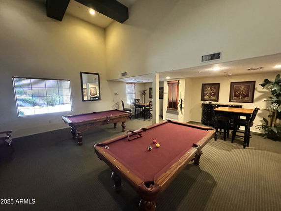Indoor recreation room with pool tables and seating area.