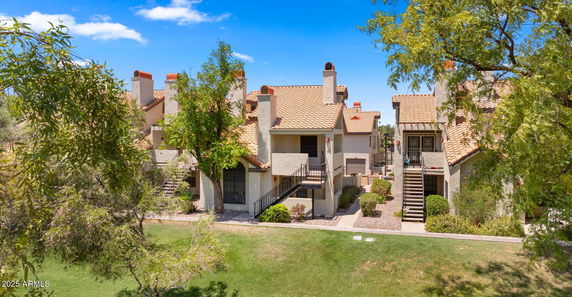 Front view of a multi-story building with stairs and multiple chimneys.