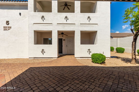 Front view of a two-story building with a white facade and decorative elements.